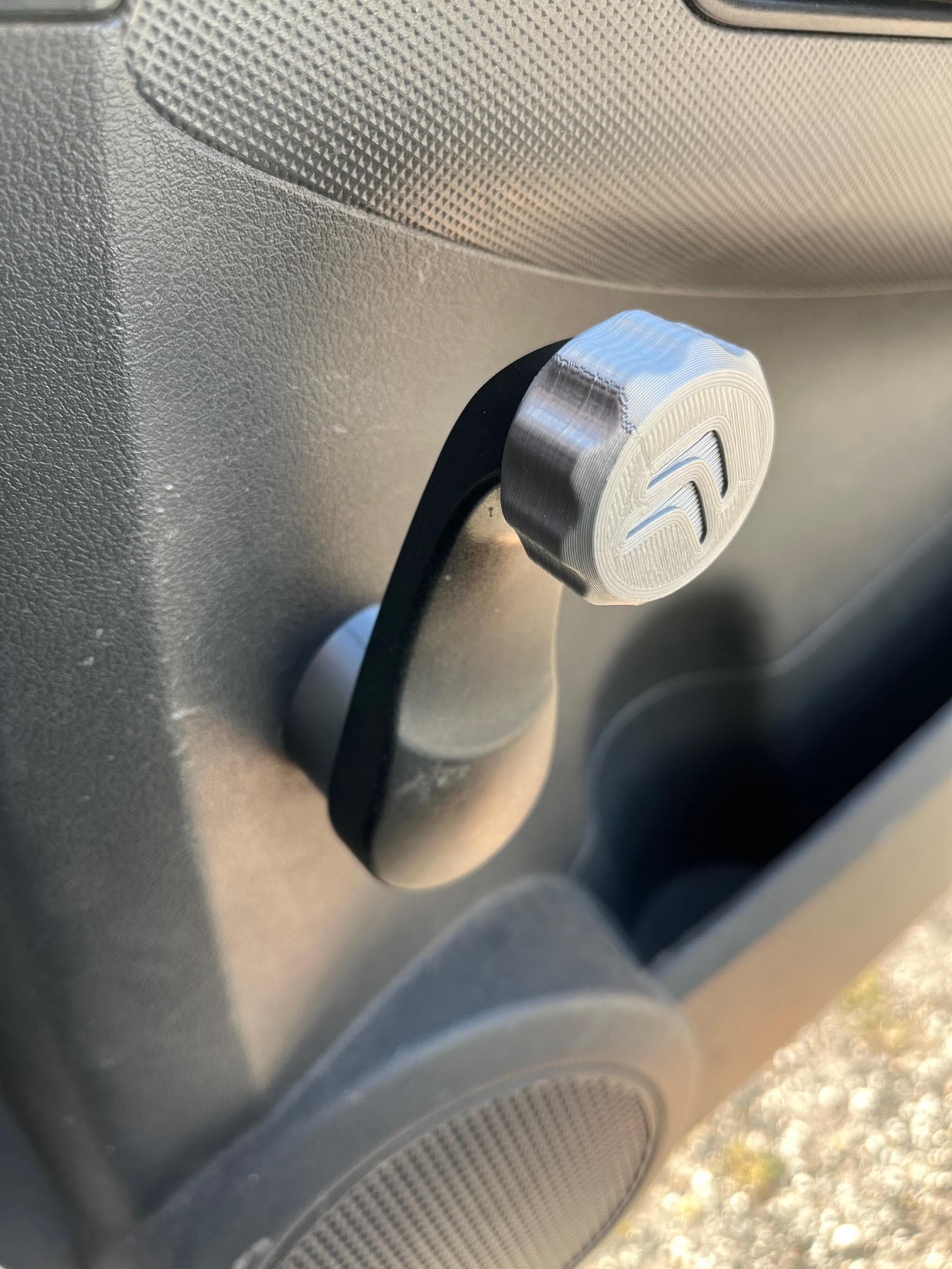 Manivelle de lève-vitre de voiture avec un bouton gris imprimé en 3D arborant un logo.